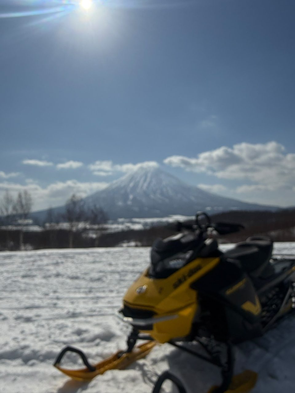 Yellow Ski-Doo snowmobile in deep Niseko powder snow