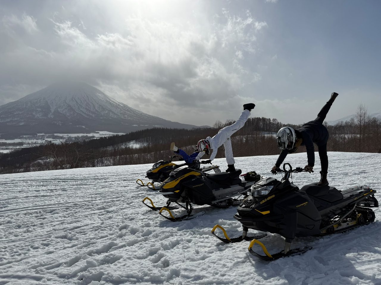 Guests having fun on their snowmobiles during a tailored Niseko snowmobile tour below Mt Yotei